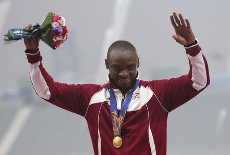 Qatar's Femi Seun Ogunode poses with his gold medal on the podium at the award ceremony for the men's 100m final at the Incheon Asiad Main Stadium during the 17th Asian Games September 28, 2014. REUTERS/Kim Kyung-Hoon