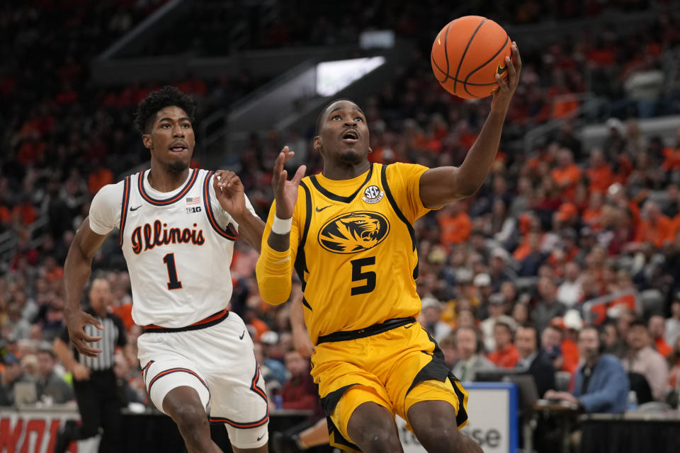 Missouri's D'Moi Hodge (5) heads to the basket as Illinois' Sencire Harris (1) defends during the second half of an NCAA college basketball game Thursday, Dec. 22, 2022, in St. Louis. Missouri won 93-71. (AP Photo/Jeff Roberson)