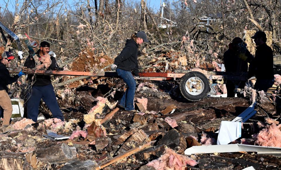 Fort Campbell military personnel and neighbors pull a trailer out from the rubble of Christina Litchfield’s destroyed home on Monday, Dec. 11, 2023, in Clarksville, Tenn. As the South gets more tornadoes, experts worry about the quality of construction and are urging communities to build homes to tougher standards.