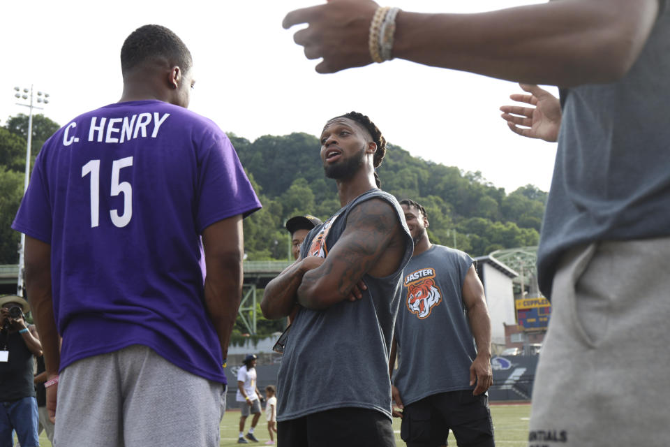 FILE - Buffalo Bills' Damar Hamlin, center, talks with Philadelphia Eagles' Miles Sanders during a celebrity kickball game hosted by NFL players at George Cupples Stadium in Pittsburgh, Saturday, June 25, 2022. Damar Hamlin plans to support young people through education and sports with the $8.6 million in GoFundMe donations that unexpectedly poured into his toy drive fundraiser after he suffered a cardiac arrest in the middle of a game last week. (AP photo via Post-Gazette)/Pittsburgh Post-Gazette via AP)