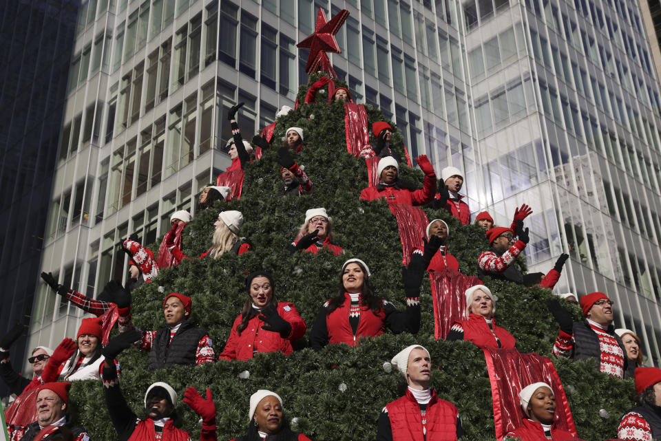 Performers on the Macy's Singing Christmas Tree float wave to spectators during the Macy's Thanksgiving Day Parade, Thursday, Nov. 24, 2022, in New York. (AP Photo/Jeenah Moon)
