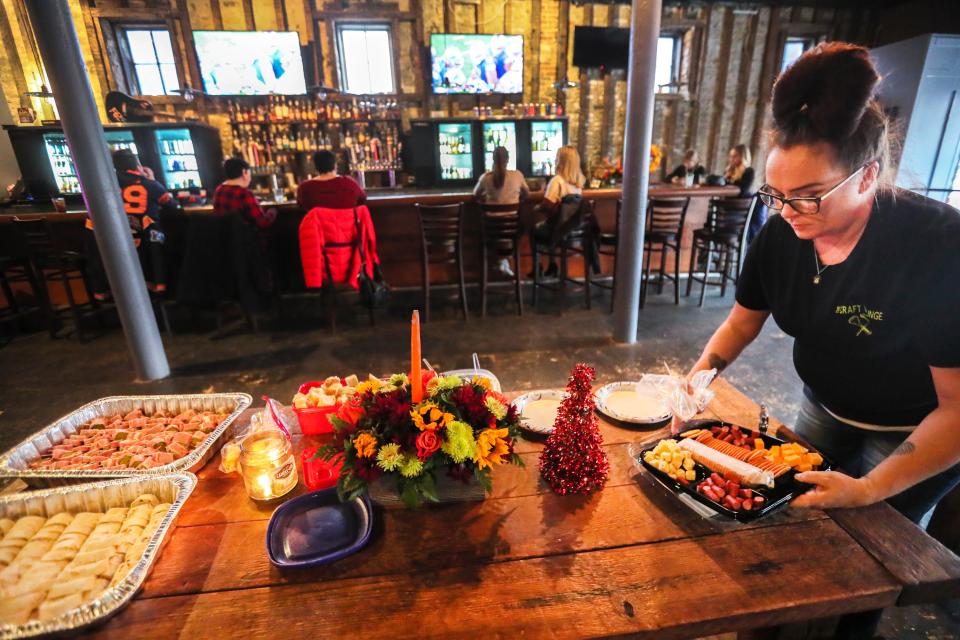 Amy Lassator, head bartender at Craft Lounge in Waukesha, places finger foods on the table before the Friendsgiving gathering Thursday, Tony Davis initially planned to host a small Friendsgiving gathering with friend,  but he opened the gathering to the public to welcome  those who needed celebration following the Christmas Parade tragedy.