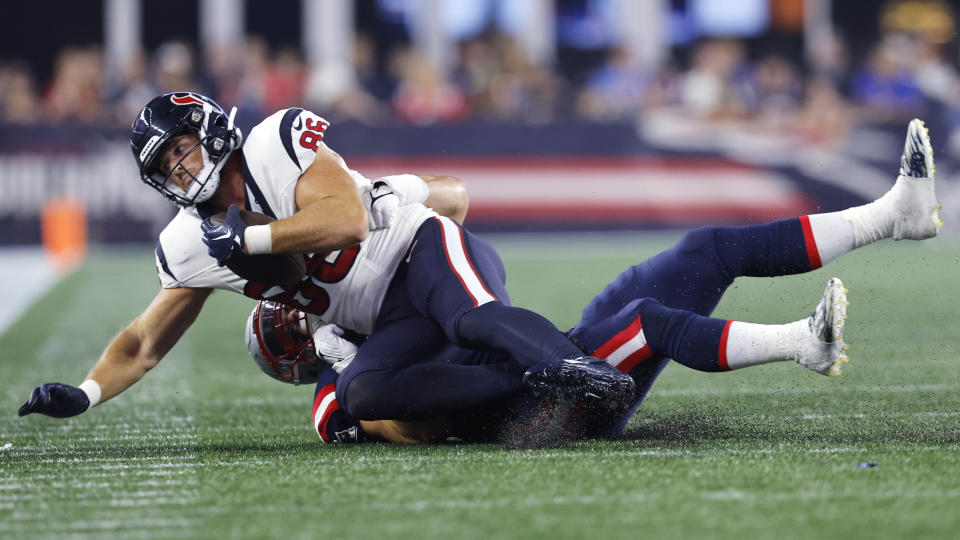 Houston Texans tight end Mason Schreck (86) hangs on to the ball while being taken down by New England Patriots linebacker Diego Fagot, rear, during the second half of an NFL preseason football game Thursday, Aug. 10, 2023, in Foxborough, Mass. (AP Photo/Michael Dwyer)