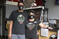 Owners of The Black Italian restaurant and catering service, Paula Hunter, right, and her husband Anthony Hunter in their empty restaurant in Louisville, Ky., Thursday, Dec. 3, 2020. The Hunter's spun off their catering service into a restaurant but now, hit with a recent statewide order closing restaurants to indoor dining until mid-December, the couple is hoping for another round of federal aid to hang on until vaccines can conquer the virus. (AP Photo/Timothy D. Easley)