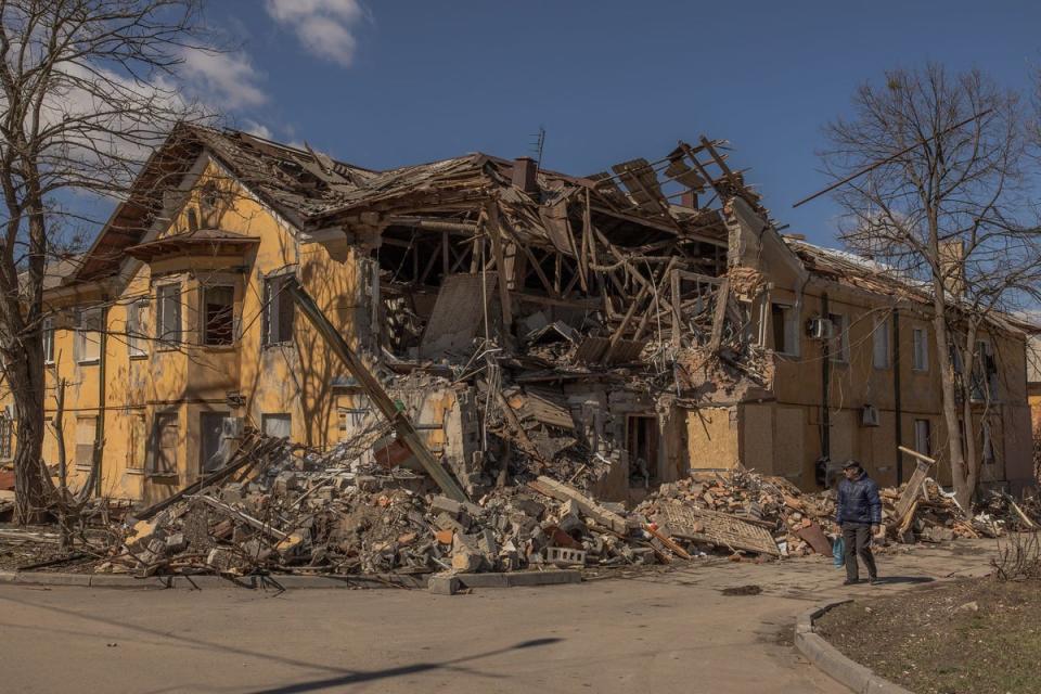 A pedestrian walks past a building that was heavily damaged following a recent shelling, in the town of Mykolaivka, near Sloviansk in the north of the Donets (AFP via Getty Images)