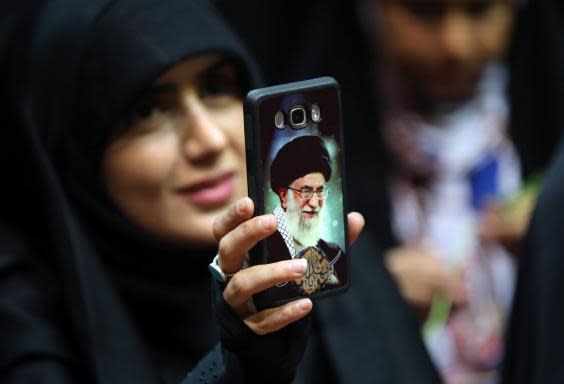 An Iranian woman shows her phone cover depicting Khamenei (AFP/Getty)