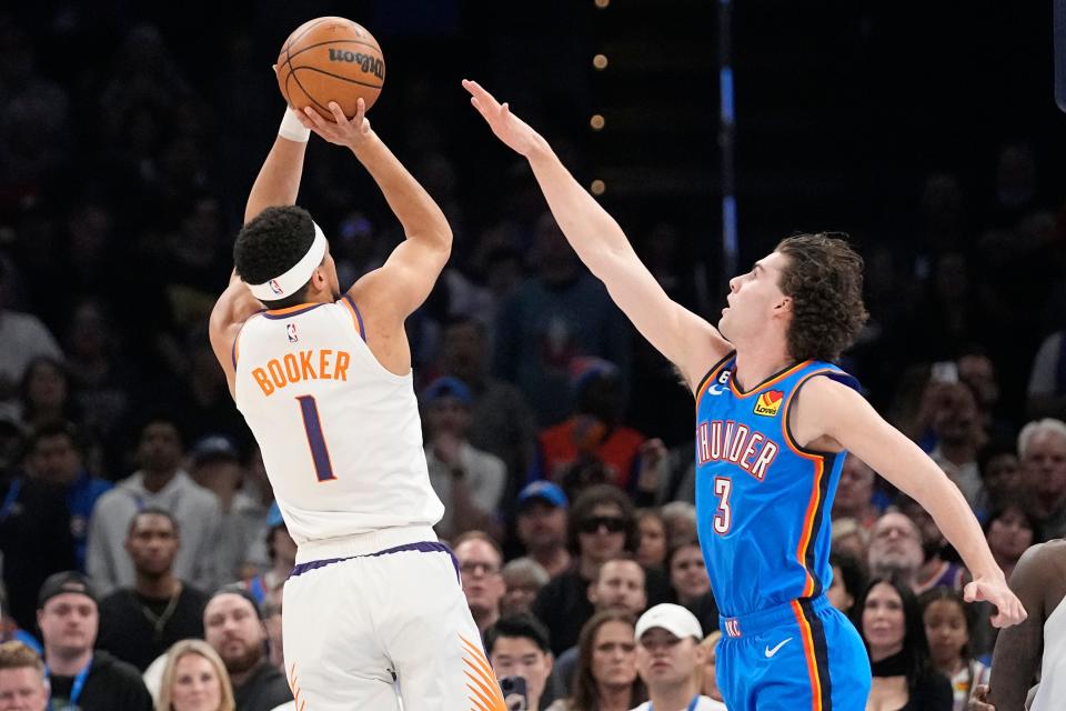 The Thunder's Josh Giddey guards Phoenix's Devin Booker (1) in a game Sunday night at Paycom Center.