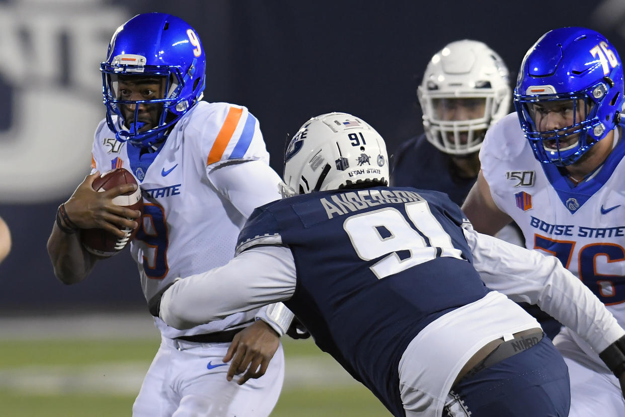 Boise State quarterback Jaylon Henderson (9) runs with the ball as Utah State defensive tackle Devon Anderson (91) moves in during the first half of an NCAA college football game Saturday, Nov. 23, 2019, in Logan, Utah. (AP Photo/Eli Lucero)