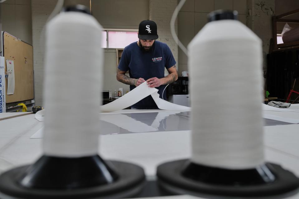 Justin Botelho works on the clear section for the wheelhouse of a boat which he is making at Cesar Marine Canvas & Upholstery on Harbor Street in New Bedford.