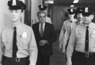 <p>Longtime Nixon confidante Charles “Bebe” Rebozo is flanked by Capitol policemen after being questioned by the Senate Watergate Committee, March 21, 1974. (Photo: AP) </p>