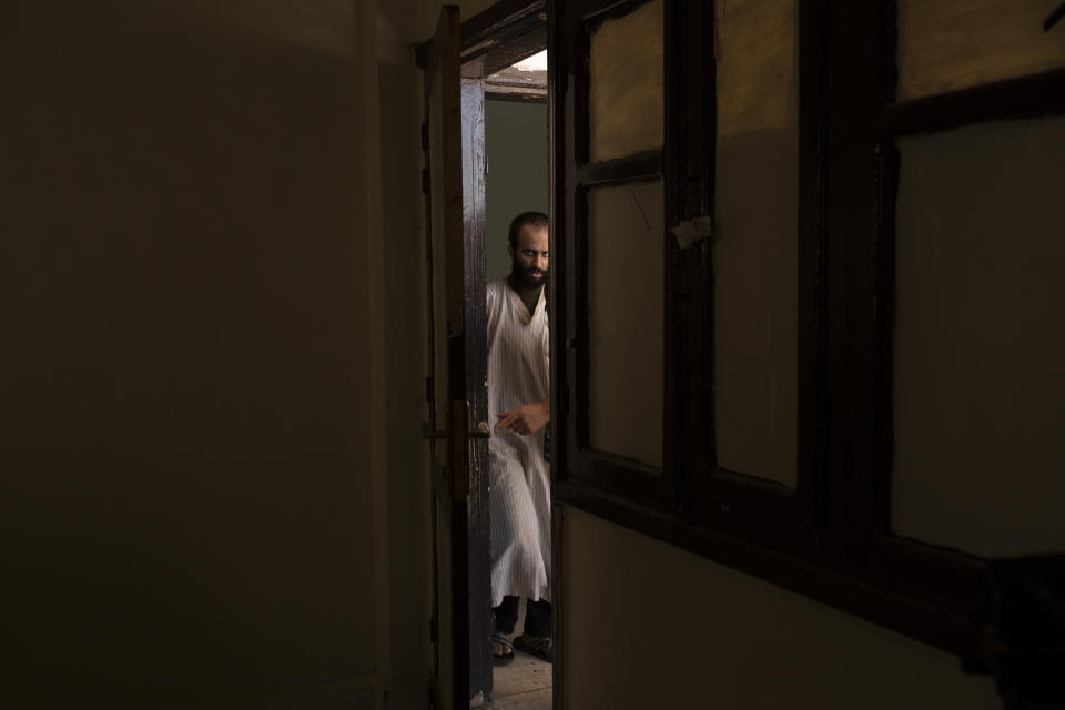 In this Sept. 4, 2019 photo, Abdul-Rahman al-Shmary, a Saudi Islamic State member who traded in Yazidi slaves and has been in a Syrian Kurdish-run prison since 2017, is led by guards to an interview in Rmeilan, northeast Syria. He dismissed the IS rules on slavery as rooted not in Islamic law but in the leadership's need for control. "It was about power and not for God's sake," he said. (AP Photo/Maya Alleruzzo)