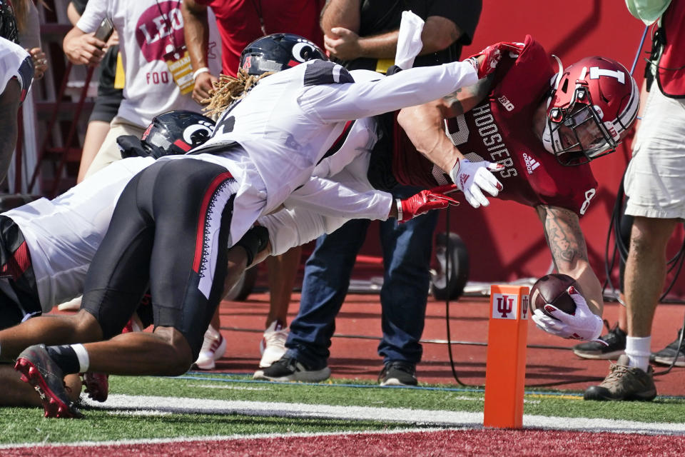 Indiana's Peyton Hendershot (86) dives over the goal line for a touchdown against Cincinnati's Bryan Cook (6) during the first half of an NCAA college football game, Saturday, Sept. 18, 2021, in Bloomington, Ind. (AP Photo/Darron Cummings)