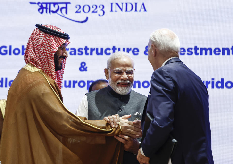 Saudi Arabian Crown Prince Mohammed bin Salman Al Saud, left, and U.S. President Joe Biden, right, shake hands next to Indian Prime Minister Narendra Modi on the day of the G20 summit in New Delhi, India, Sept. 9, 2023. (AP Photo/Evelyn Hockstein, Pool)