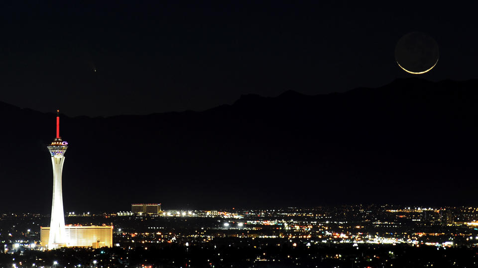 LAS VEGAS, NV - MARCH 12:  The comet PanSTARRS, above and to the right, passes over the Stratosphere Casino Hotel along with a waxing crescent moon over the Spring Mountains range on March 12, 2013 in Las Vegas, Nevada. Officially known as C/2011 L4, the comet got its name after being discovered by astronomers using the Panoramic Survey Telescope & Rapid Response System (Pan-STARRS) telescope in Hawaii in June 2011.  (Photo by Ethan Miller/Getty Images)