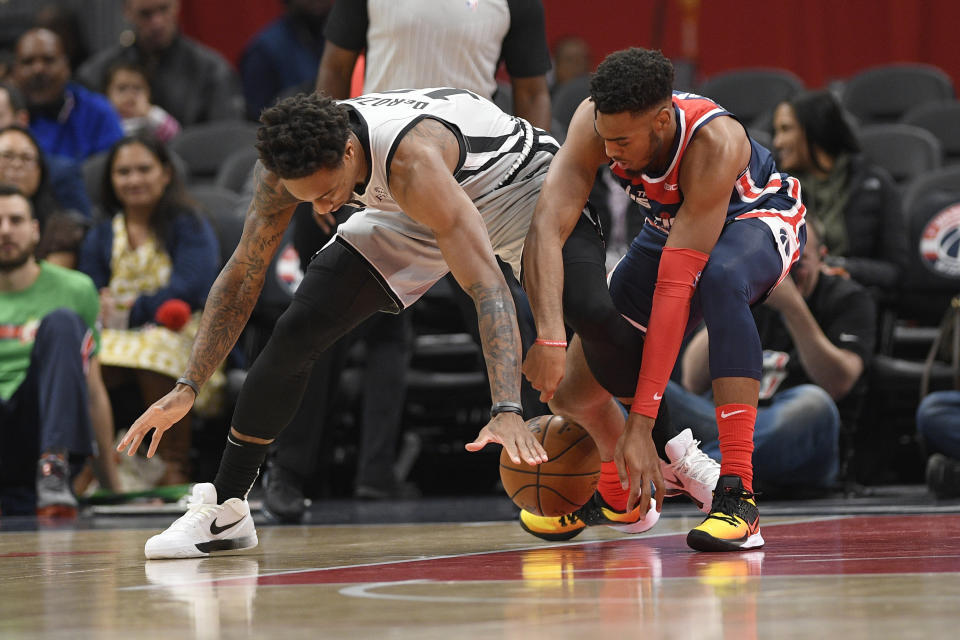San Antonio Spurs guard DeMar DeRozan, left, and Washington Wizards guard Troy Brown Jr. reach for the ball during the first half of an NBA basketball game Wednesday, Nov. 20, 2019, in Washington. (AP Photo/Nick Wass)