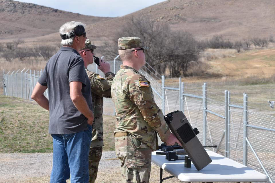 Two Wisconsin National Guardsmen identify drones with their instructor.
