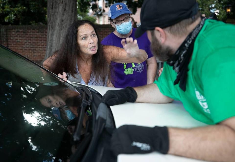 Deborrah Newton works remove a protester from the hood of her car at the intersection of Jones and Blount Streets on Thursday, July 2, 2020 in Raleigh, N.C, Five other protesters stopped the car initially next to the Executive Mansion, before Newton exited her car and tried to remove the man.