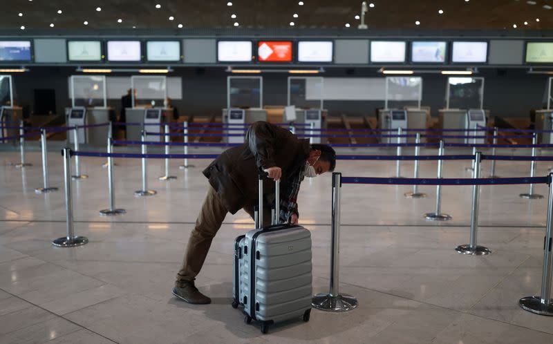 A passenger waits for check-in in the departures area of the Terminal 2E at Charles-de-Gaulle airport in Roissy