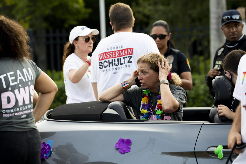 Rep. Debbie Wasserman Schultz, D-Fla., makes a call after a truck drove into a crowd of people during The Stonewall Pride Parade and Street Festival in Wilton Manors, Fla., Saturday, June 19, 2021. A driver has slammed into spectators at the start of a Pride parade in South Florida, injuring at least two people. (Chris Day/South Florida Sun-Sentinel via AP)