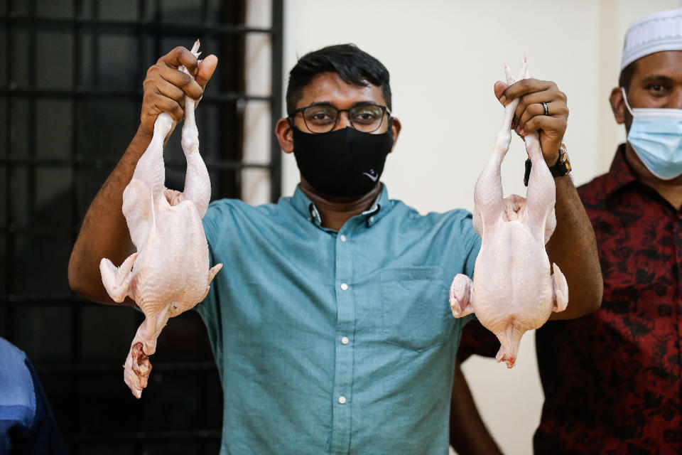 Penang Traders Association vice-chairman Muhammad Shaffi Yacob showing the difference between slaughtered (left) and frozen (right) chicken during the press conference in Penang January 11, 2021. — Picture by Sayuti Zainudin