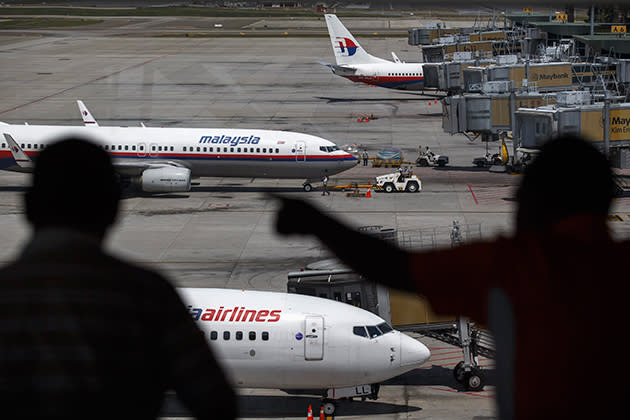 People look at Malaysia Airline aircraft sitting on the tarmac at a viewing gallery in Kuala Lumpur International Airport in Sepang July 19, 2014. (REUTERS/Athit Perawongmetha)