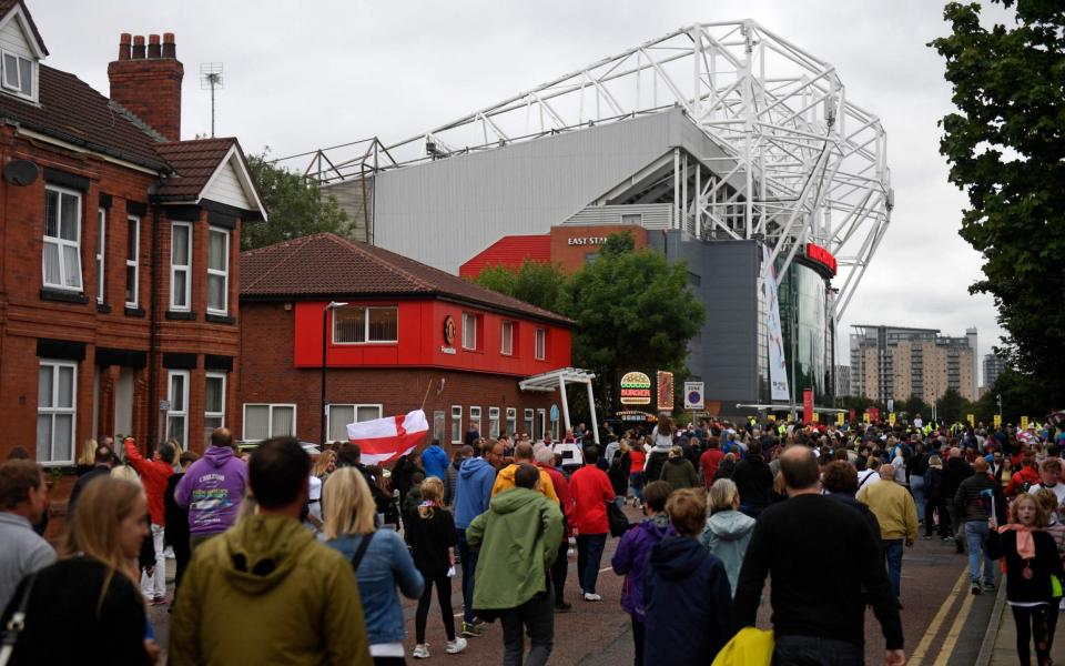 Supporters arrive for the UEFA Women's Euro 2022 Group A football match between England and Austria at Old Trafford in Manchester, north-west England on July 6, 2022. - Oli Scarff/AFP