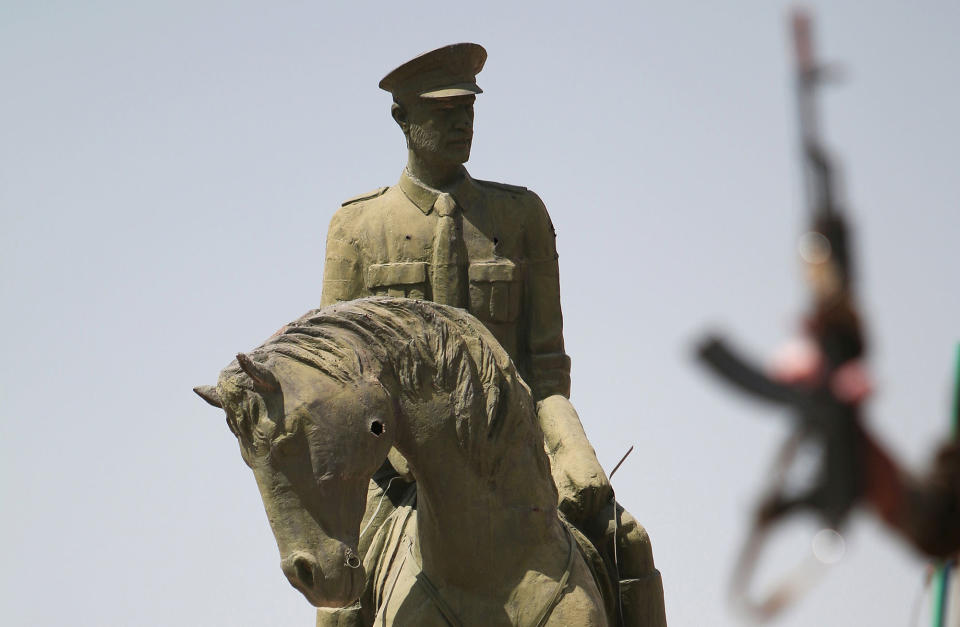 <p>A Kurdish fighter carries his weapon near a statue of Bassel al-Assad, brother of Syria’s President Bashar, in the Ghwairan neighborhood of Hasaka, Syria on Aug. 23, 2016. (Rodi Said/Reuters) </p>