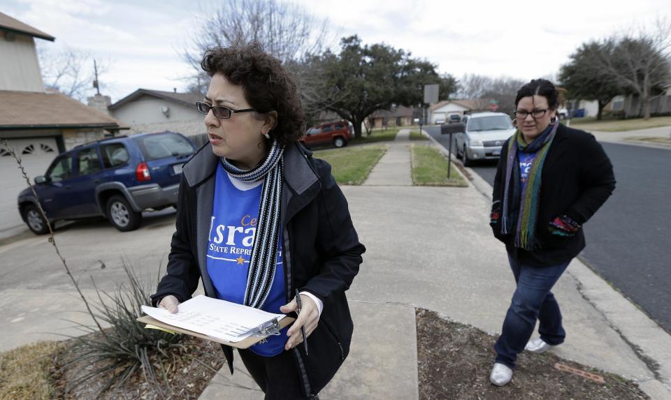 FILE - In this Jan. 28, 2014 file photo, Texas House of Representatives hopeful Celia Israel, left, walks door-to-door asking for votes, in Austin, Texas. A year ago this week Democrats created an organization to revitalize and rebuild a moribund party with the longest losing streak in the country. And while there are few competitive races in the Democratic primaries, one key measure of the party’s health is whether a charismatic candidate like Wendy Davis and a voter-mobilizing group like Battleground Texas has sparked the enthusiasm necessary to boost turnout. (AP Photo/Eric Gay, File)