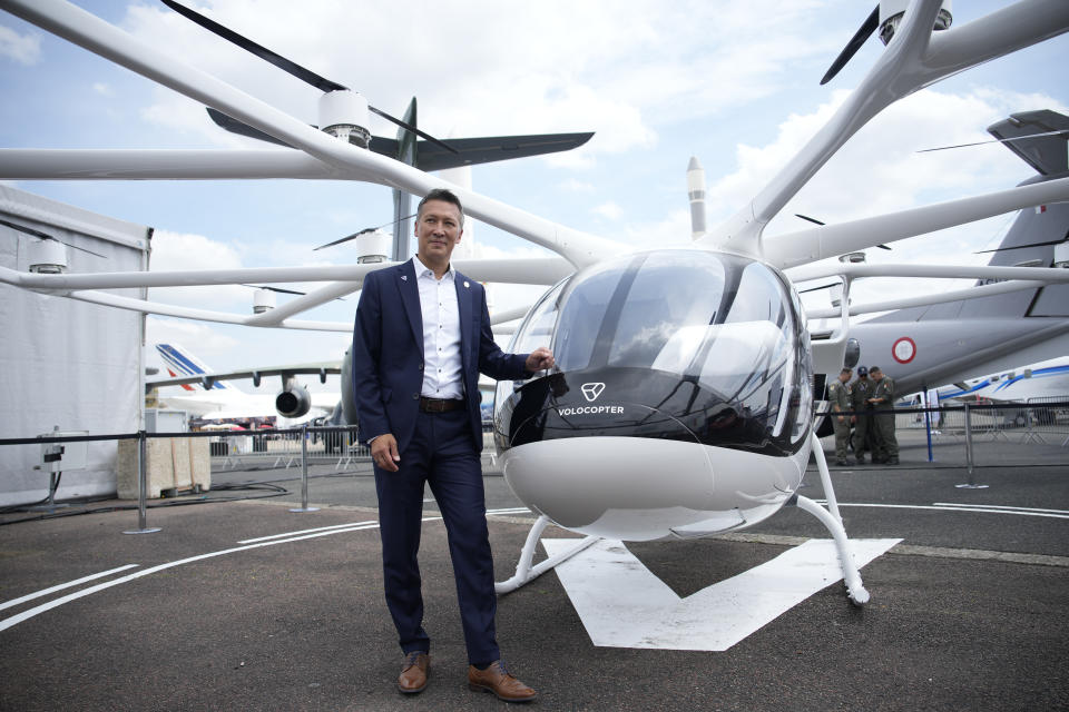 Volocopter CEO Dirk Hoke poses for a picture next to the Volocopter 2X, an electric vertical takeoff and landing multicopter, during the Paris Air Show in Le Bourget, north of Paris, France, Monday, June 19, 2023. (AP Photo/Lewis Joly)