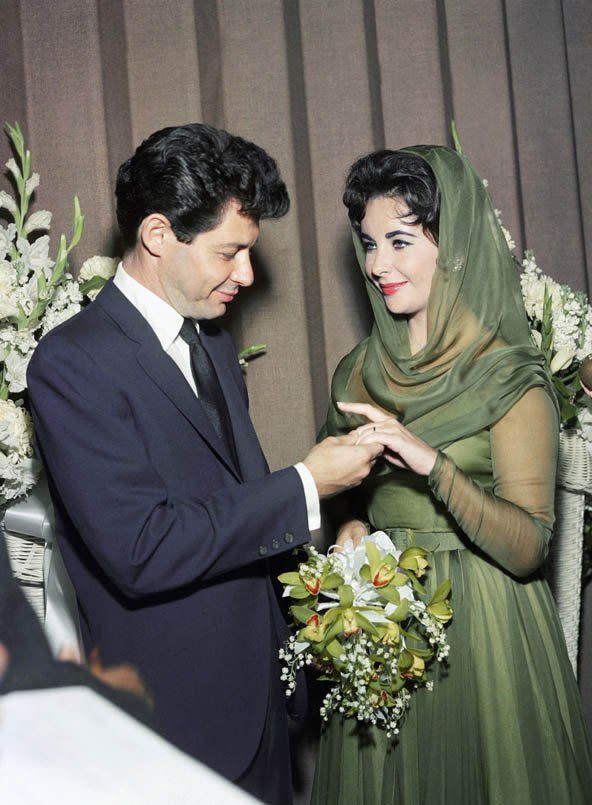 <p>Nós adoramos casamentos – mas provavelmente não tanto quanto Liz Taylor, que se casou oito vezes. Isso significa que ela usou oito vestidos diferentes! Gostamos bastante desta peça de organza verde com capuz de seda, usada por ela em seu quarto casamento. [<i>Foto: Getty</i>]</p>