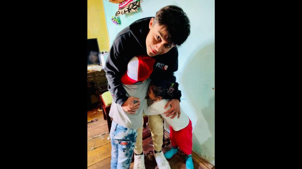 Adrian E. Sanchez hugs two Colombian children on a visit to help families in Bogota. He and Joshua Strauss collected donations and delivered them to vulnerable families.