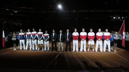 France's Davis Cup tennis team (L) and Switzerland's Davis Cup tennis team (R) pose on the court before the start of the Davis Cup final at the Pierre-Mauroy stadium in Villeneuve d'Ascq, near Lille, November 21, 2014. REUTERS/Gonzalo Fuentes