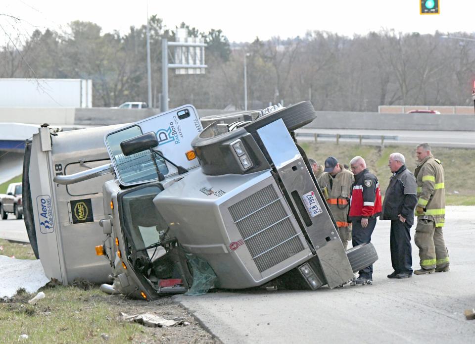 Firefighters examine the scene of a semitractor-trailer rollover on Ohio Route 39 near U.S.30.