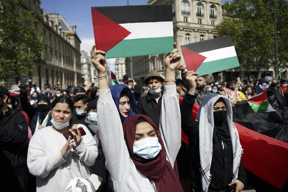 Protesters hold placards depicting the Palestinian flag in Paris, Saturday, May 22, 2021, as they take part in a rally supporting Palestinians. Egyptian mediators held talks Saturday to firm up an Israel-Hamas cease-fire as Palestinians in the Hamas-ruled Gaza Strip began to assess the damage from 11 days of intense Israeli bombardment.Supporters of the Palestinians. (AP Photo/Thibault Camus)