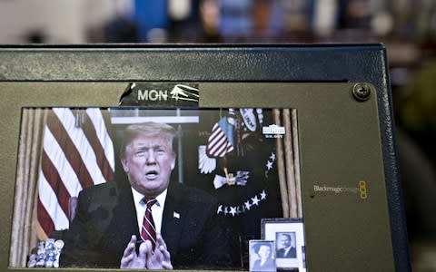 A television monitor in the White House press briefing room broadcasts U.S. President Donald Trump's address on border security in Washington, D.C. on Tuesday - Credit: Andrew Harrer/Bloomberg