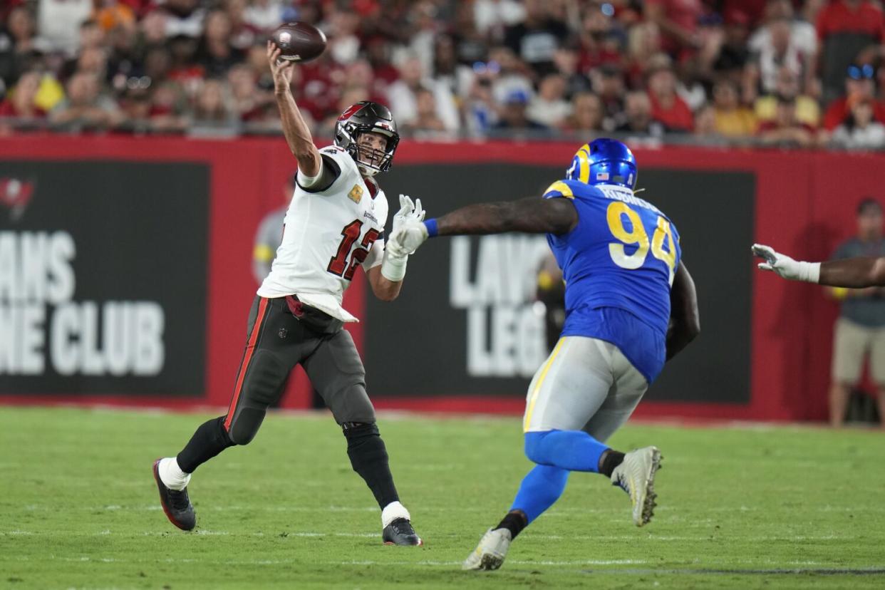 Buccaneers quarterback Tom Brady (12) throws while being rushed by Rams defensive tackle A'Shawn Robinson.