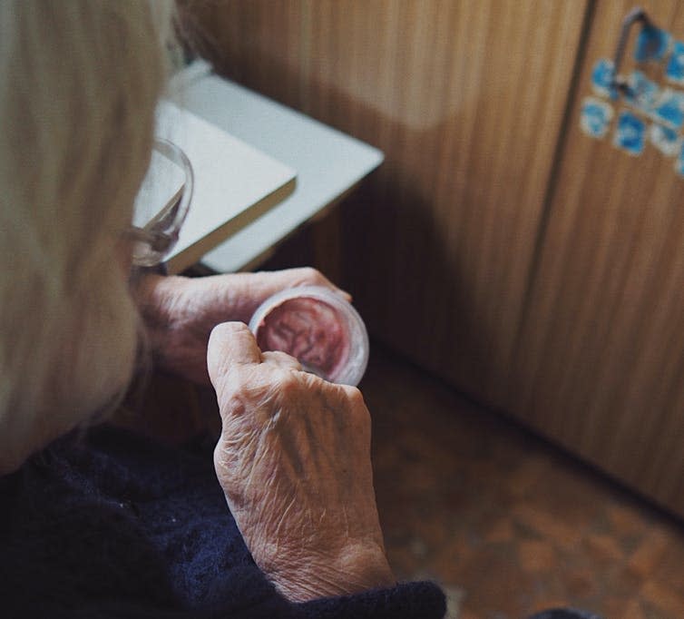 Old woman in care home eating a yoghurt