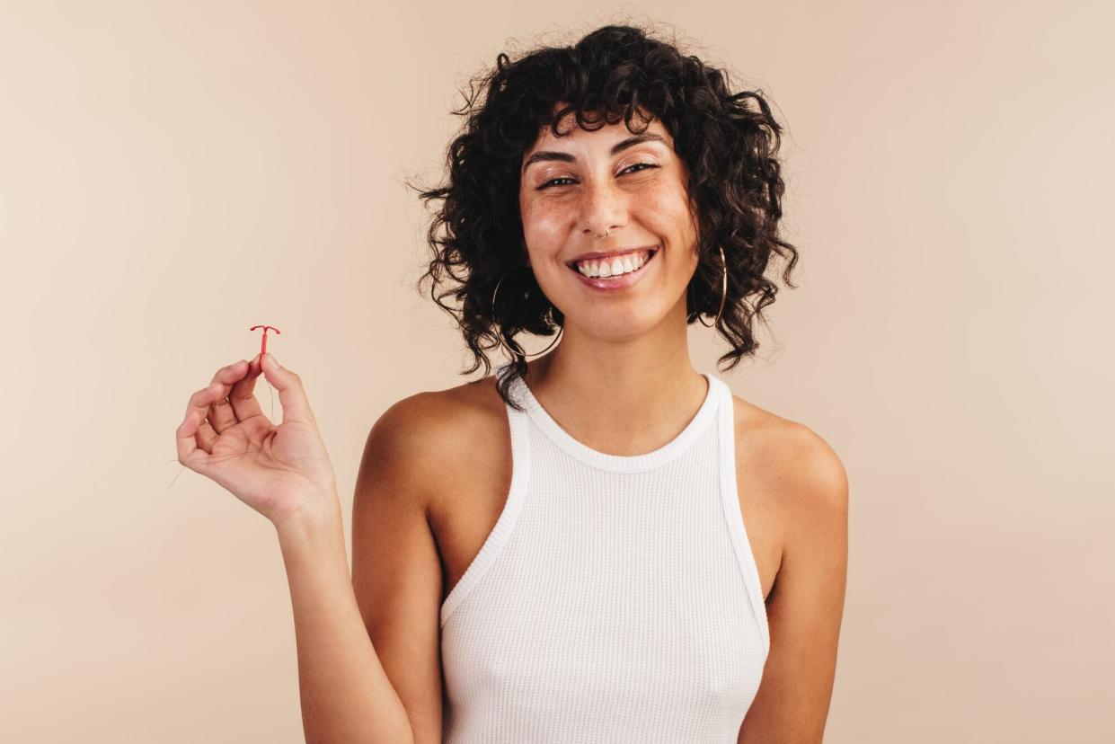 Young woman holding a copper IUD in her hand