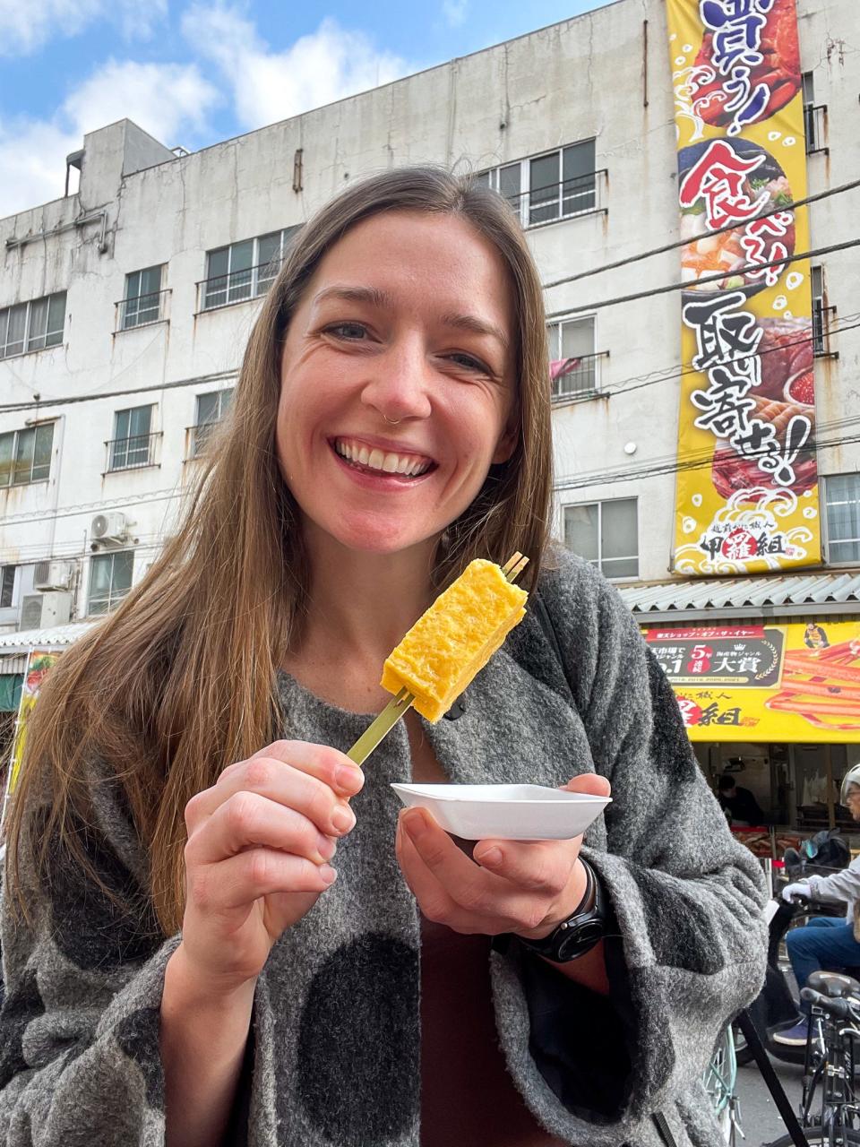 The author eats food from a stand at a food market in Tokyo.