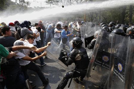 Anti-government protesters clash with police during a protest in Caracas March 12, 2014. REUTERS/Carlos Garcia Rawlins