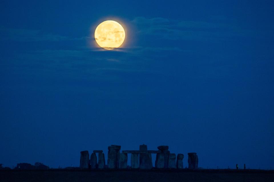 The moon sets over Stonehenge on May 26, 2021, in Amesbury, United Kingdom. May’s full moon, the “Flower Moon" will be the biggest and brightest of 2021, which will reach its peak this Wednesday and is the closest to the Earth this year.