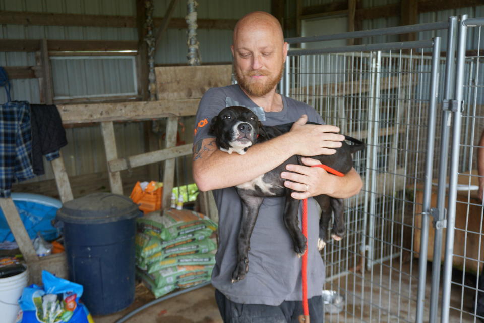 An ASPCA rescuer carries one of the dogs found on the property. (Photo: ASPCA)