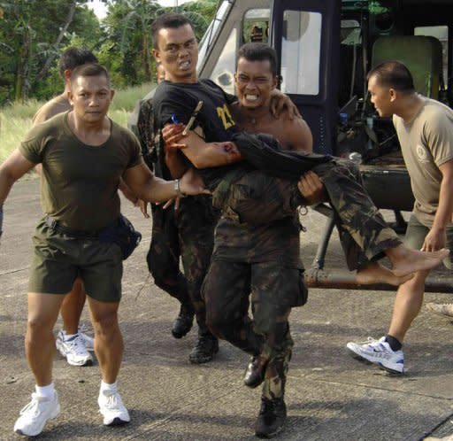 In this photo, released by the Philippine Army's Western Mindanao Command, a wounded Philippine soldier is carried by his comrades after a clash with the country's largest Muslim guerrilla group,the Moro Islamic Liberation Front (MILF), in Basilan, southern Philippines, on October 18