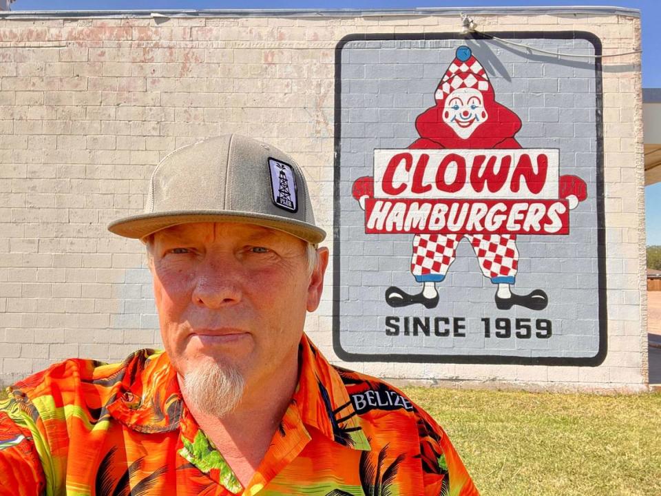 Willis Odell in front of the wall sign in 2022 after he bought Clown Burger in Haltom City. The sign was painted over by remodeling crews Jan. 19, 2024.