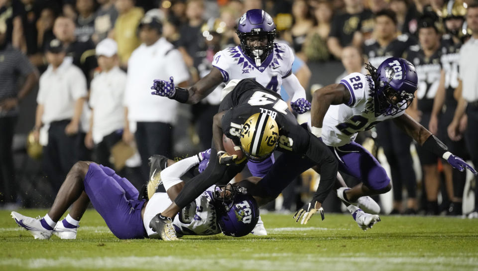 Colorado wide receiver Maurice Bell, front center, is pulled down after catching a pass, by TCU cornerback Josh Newton and safeties Abraham Camara and Millard Bradford, from left, during the first half of an NCAA college football game Friday, Sept. 2, 2022, in Boulder, Colo. (AP Photo/David Zalubowski)