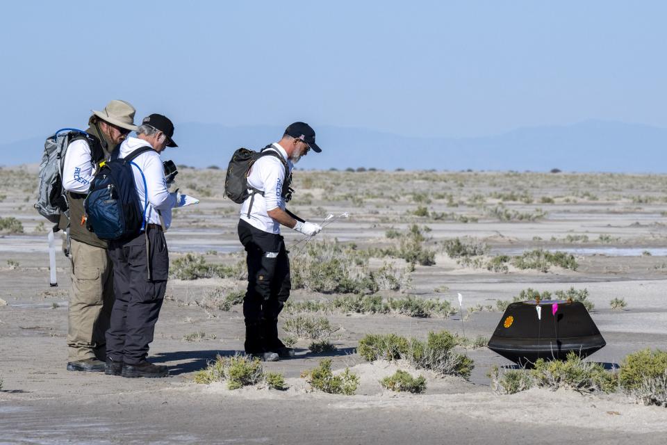In this photo provided by NASA, from left, NASA Astromaterials Curator Francis McCubbin, NASA Sample Return Capsule Science Lead Scott Sandford and University of Arizona Osiris-Rex Principal Investigator Dante Lauretta, collect data next to the sample return capsule from NASA’s Osiris-Rex mission after it landed at the Department of Defense’s Utah Test and Training Range on Sunday, Sept. 24, 2023. The sample was collected from the asteroid Bennu in October 2020. | Keegan Barber, NASA via Associated Press