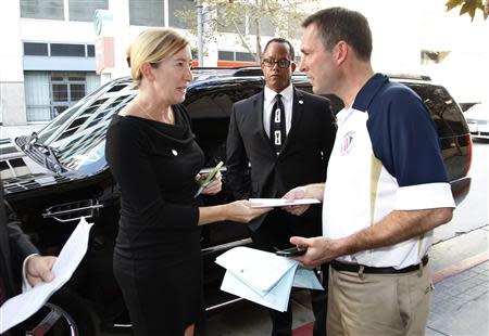 Ibi Fleming (L), senior vice president of Herbalife in North America, presents a letter from Herbalife to Brent Wilkes, national executive director of the League of United Latin American Citizens, during a protest against the nutrition and supplements company outside the Ronald Reagan State Office building in Los Angeles, California October 18, 2013. REUTERS/Fred Prouser