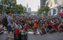 Pro-democracy protesters flash three-fingers salute during a protest rally at Ratchaprasong business district in Bangkok, Thailand, Sunday, Oct. 25, 2020. Pro-democracy protesters in Thailand gathered again Sunday in Bangkok, seeking to keep up pressure on the government a day ahead of a special session of Parliament called to try to ease political tensions. (AP Photo/Gemunu Amarasinghe)