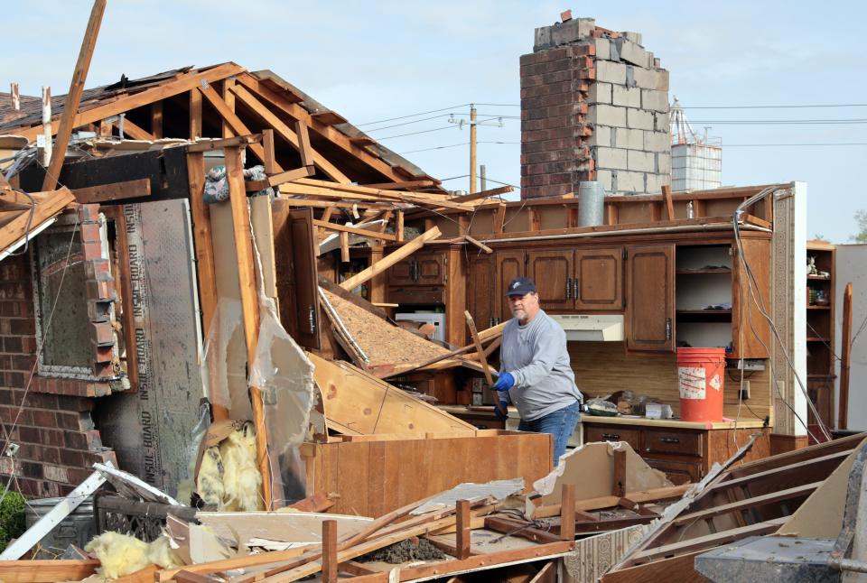 Kent Reynolds removes debris from Wednesday's tornado at his mother-in-law's house on April 20, 2023, in Cole, Okla.