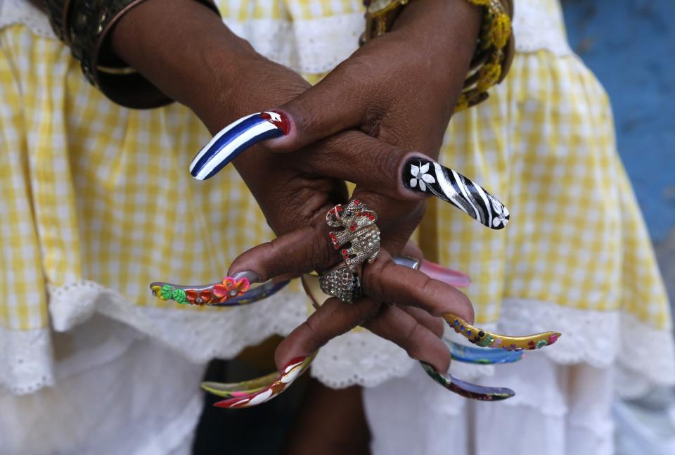 FILE - In this Jan. 15, 2015 file photo, fortune teller Adelaida waits for her nail polish to dry as she sits on the sidewalk in Old Havana, Cuba. (AP Photo/Desmond Boylan, File)